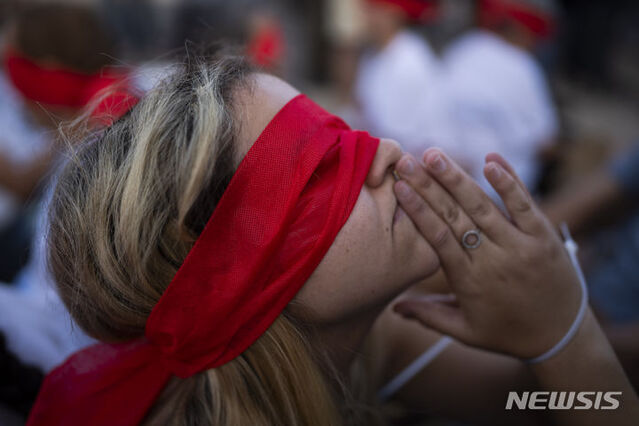 ▲ 2일 이스라엘 텔아비브에서 크파르 아자 키부츠 주민들이 눈을 가리고 손을 묶은 채 하마스에 납치된 주민들의 석방을 촉구하고 있다. 이 작은 키부츠에서는 지난달 7일 어린이 7명 포함 18명의 주민이 하마스에 납치됐으며 그중 가장 어린아이는 3세였다. ⓒAP/뉴시스