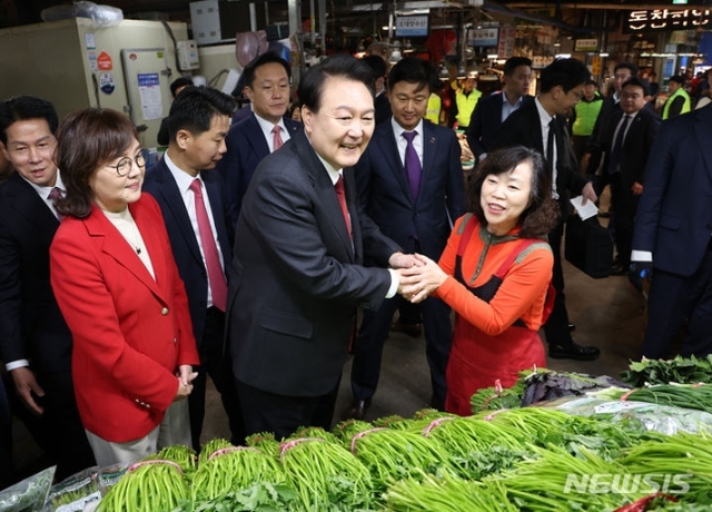 ▲ 윤석열 대통령이 7일 대구 북구 칠성종합시장을 방문, 미나리를 판매하는 상인과 악수하고 있다. ⓒ뉴시스