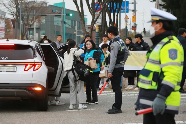 ▲ 현대제철 당진제철소 임직원들이 16일 오전 당진고 앞에서 생수와 핫팩을 전하며 수능대박을 기원하고 있다.ⓒ현대제철