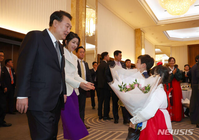 ▲ 영국을 국빈 방문한 윤석열 대통령과 부인 김건희 여사가 20일(현지시간) 런던 시내 한 호텔에서 열린 동포 초청 만찬 간담회에서 화동으로부터 꽃다발을 받고 있다.ⓒ뉴시스