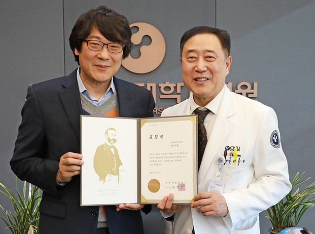 ▲ 권계철 세종충남대병원 원장(오른쪽)이 인간의 생명보호를 위한 혈액사업 발전 및 선진화에 기여한 공로로 대한적십자사회장 표창을 받고 있다.ⓒ세종충남대병원