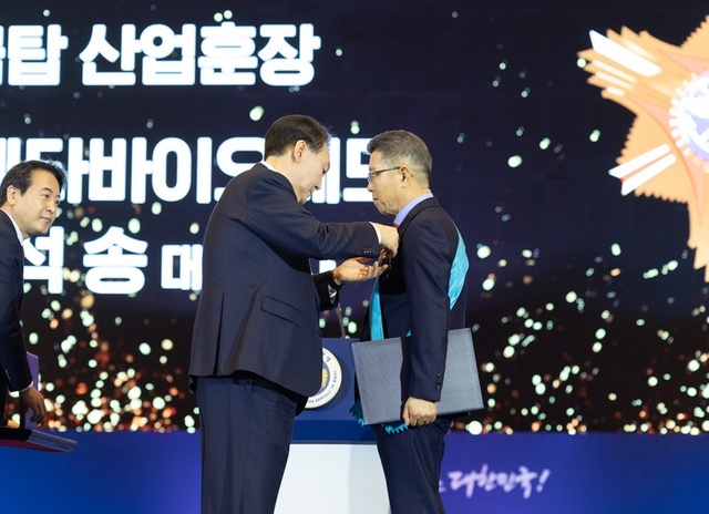 ▲ 오석송 ㈜메타바이오메드 회장이 윤석열 대통령으로부터 금탑산업훈장을 받고 있다. ⓒ㈜메타바이오메드