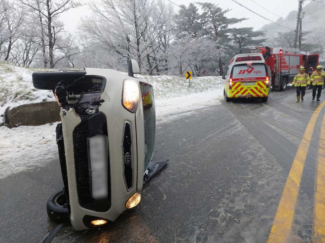 ▲ 15일 강원지역에 눈이 내린 가운데 도로가 빙판길이 되면서 운행 중인 승용차가 옆으로 넘어져 있다.ⓒ강원소방본부