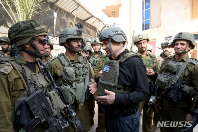 ▲ 베냐민 네타냐후(오른쪽) 이스라엘 총리가 성탄절인 25일(현지시각) 가자지구 북부를 방문해 장병들과 얘기하고 있다. 네타냐후 총리는 앞서 의회에서 “전쟁은 오래 걸릴 것이고 끝나려면 아직 멀었다”라고 말했다. ⓒAP/뉴시스