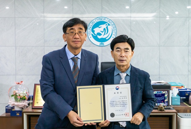 ▲ 29일 교육부장관 표창을 받은 영진사이버대학교 윤재웅 교수(왼쪽)가 조방제 총장으로부터 축하를 받으며 교내 회의실에서 기념 촬영을 하고 있다.ⓒ영진사이버대