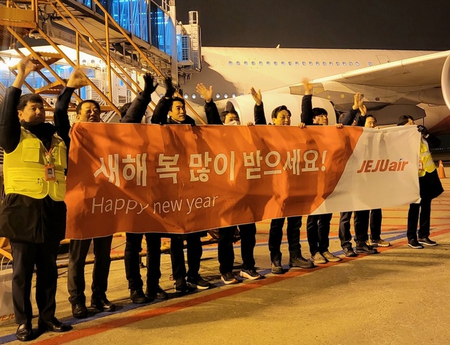▲ 김이배(왼쪽 여섯 번째) 제주항공 대표와 임직원들이 인천국제공항에서 새해 첫 출발편탑승객들에게 인사를 하고 있다. ⓒ제주항공