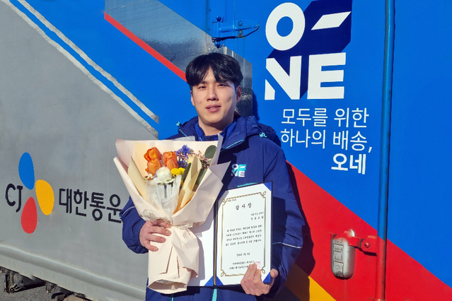 ▲ CJ대한통운 택배기사 정보교씨가 지난해 12월 번동에서 화재를 막은 공로로 수령한 감사장을 들고 기념사진 촬영을 하고 있다. ⓒCJ대한통운