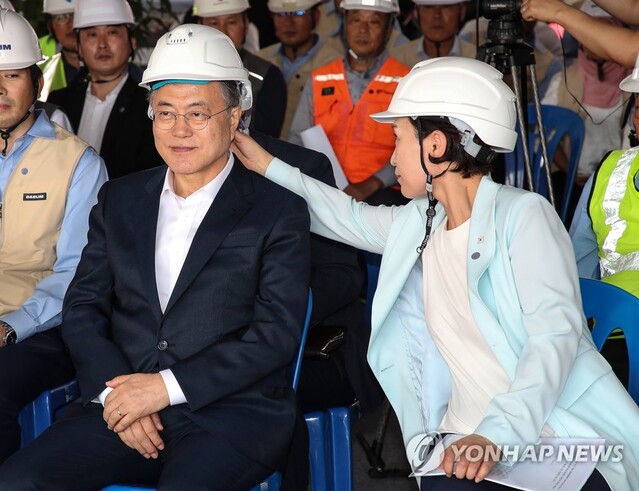 ▲ 2019년 3월 문재인 전 대통령이 쓴 안전모를 김현미 전 국토교통부 장관이 만져주고 있는 모습. ⓒ연합뉴스