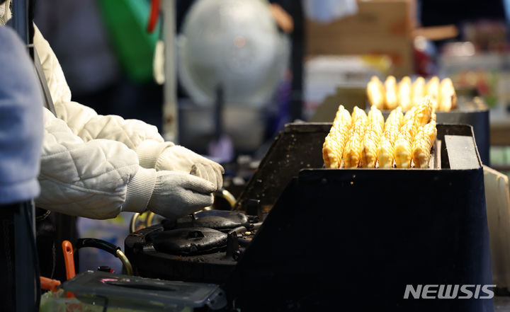 ▲ 서울 중구 명동거리에서 한 상인이 붕어빵 기계에 손을 녹이고 있다. ⓒ뉴시스