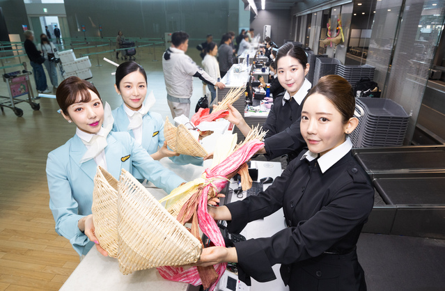▲ 대한항공 직원들이 인천공항 제2여객터미널 대한항공 카운터에서 복조리를 들고 기념촬영을 하고 있다. ⓒ대한항공