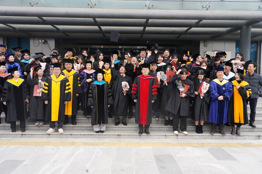 ▲ 수성대 졸업생들이 젬마관 앞에서 이동구 이사장과 김선순 총장과 기념촬영하며 학사모를 던지고 있다.ⓒ수성대