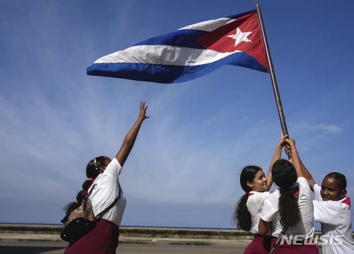 ▲ [아바나=AP/뉴시스] 8일(현지시각) 쿠바 아바나에서 학생들이 피델 카스트로가 이끄는 혁명군 수도 입성 제65주년 기념 퍼레이드를 환영하며 국기를 흔들고 있다. 카스트로는 1959년 1월 8일 혁명군을 이끌고 수도에 입성해 친미 독재 정권을 몰아내는 쿠바 혁명에 마침표를 찍었다. 2024.01.09. ⓒ뉴시스