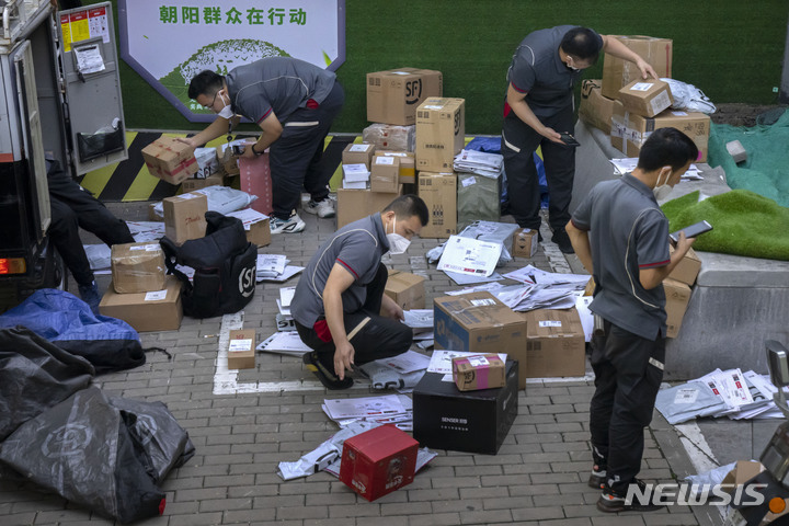 ▲ 지난해 7월 28일 중국 베이징의 거리에서 택배 상자들을 분류하는 모습. ⓒAP/뉴시스