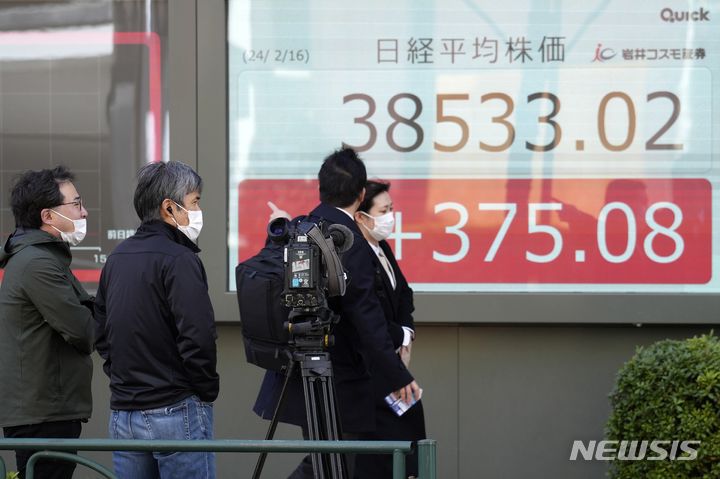 ▲ 지난 16일 일본 도쿄의 한 금융사 전광판 앞을 시민들이 지나가고 있다. ⓒAP/뉴시스