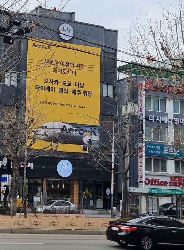 ▲ 본정 초콜릿㈜ 사옥에 걸린 청주국제공항 거점 에어로케이항공.ⓒ본정 초콜릿