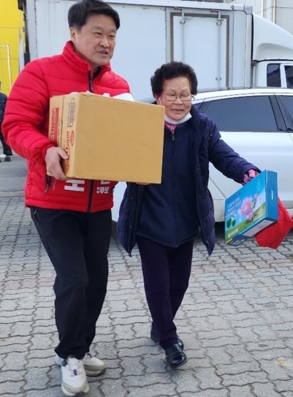 ▲ 국민의힘 김학도 예비후보가 청주 흥덕에서 한 할머니가 힘들게 들고 가는 종이 박스를 번쩍 들어 할머니 집까지 가져다 주고 있다.ⓒ김학도 선거사무소