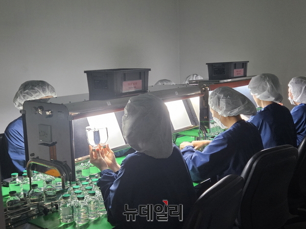 ▲ 오창공장 직원들이 약물을 충전한 바이알을 검병하고 있다.ⓒ최영찬 기자