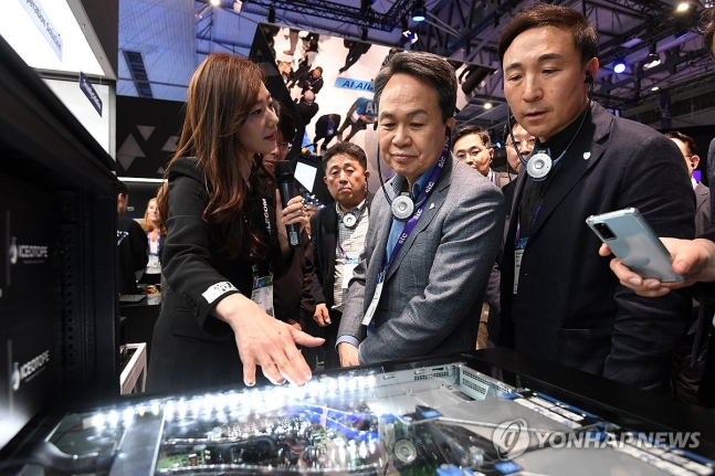 ▲ 진옥동 신한금융그룹 회장(앞줄 가운데)이 'MWC 2024' 개막 이틀째인 27일(현지시간) 스페인 바르셀로나 피라 그란 비아 전시장 내 SKT 부스를 찾아 관계자로부터 설명을 듣고 있다.ⓒ 연합뉴스 제공