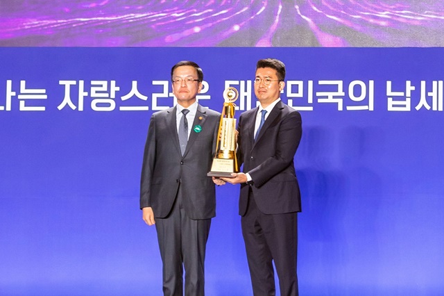 ▲ 4일 오전 10시 서울 동대문디자인플라자(DDP)에서 열린 제58회 납세자의 날 기념식에서 우아한형제들이 고액 납세의 탑 수상 법인으로 선정됐다. 우아한형제들 이국환 대표(오른쪽)가 최상목 부총리 겸 기획재정부 장관으로부터 고액 납세의 탑 트로피를 받고 기념 사진을 촬영하고 있다.ⓒ우아한형제들