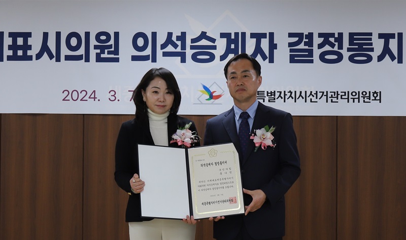 ▲ 국민의힘 세종시의회 비례대표 2번 홍나영 씨가 의석 승계자 결정서를 받고 있다.ⓒ세종시선관위