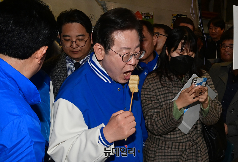 ▲ 이재명 더불어민주당 대표가 지난 21일 충남 아산시 온양온천시장을 방문해 어묵을 먹고 있다. ⓒ이종현 기자