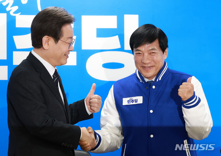 ▲ 이재명 더불어민주당 대표가 2월 23일 오전 서울 영등포구 중앙당사에서 열린 인재영입식에서 이성윤 전 서울중앙지검장에게 당 점퍼를 입혀주고 있다. ⓒ뉴시스