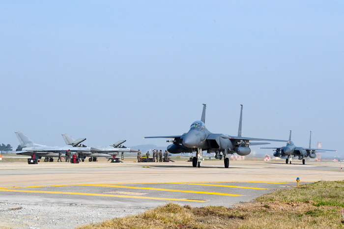 ▲ 한미공군은 12~26일 최대규모의 연합공중훈련인 '2024년 연합편대군 종합훈련'을 군산 공군기지에서 실시한다. 사진은 훈련에 참가하기 위해 주기된 우리 공군 F-16(왼쪽 2기) 앞을 지나 택싱하고 있는 우리 공군의 F-15K. ⓒ공군 제공