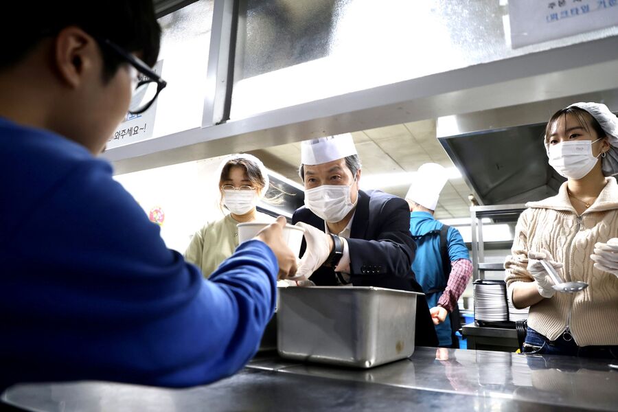 ▲ 원용걸 서울시립대학교 총장이 조리 로봇으로 만든 무료 저녁 식사를 학생들에게 직접 배식하고 있다. ⓒ서울시립대