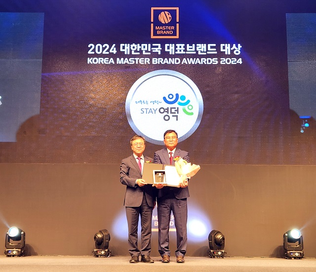 ▲ 영덕군 백영복 해양수산과장(오른쪽)이 정종태 한경닷컴 대표이사로부터 대표브랜드 대상을 축하받고 있다.ⓒ영덕군