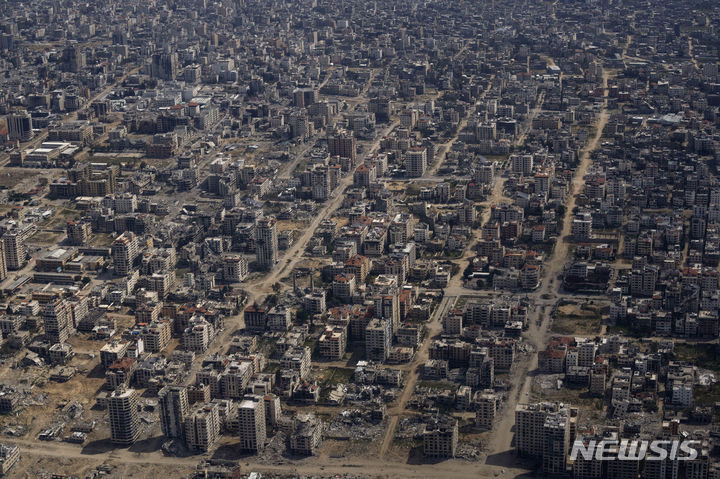 ▲ 가자지구 상공을 비행하는 미 공군의 수송기 창밖으로 파괴된 건물 잔해들의 모습. ⓒAP/뉴시스