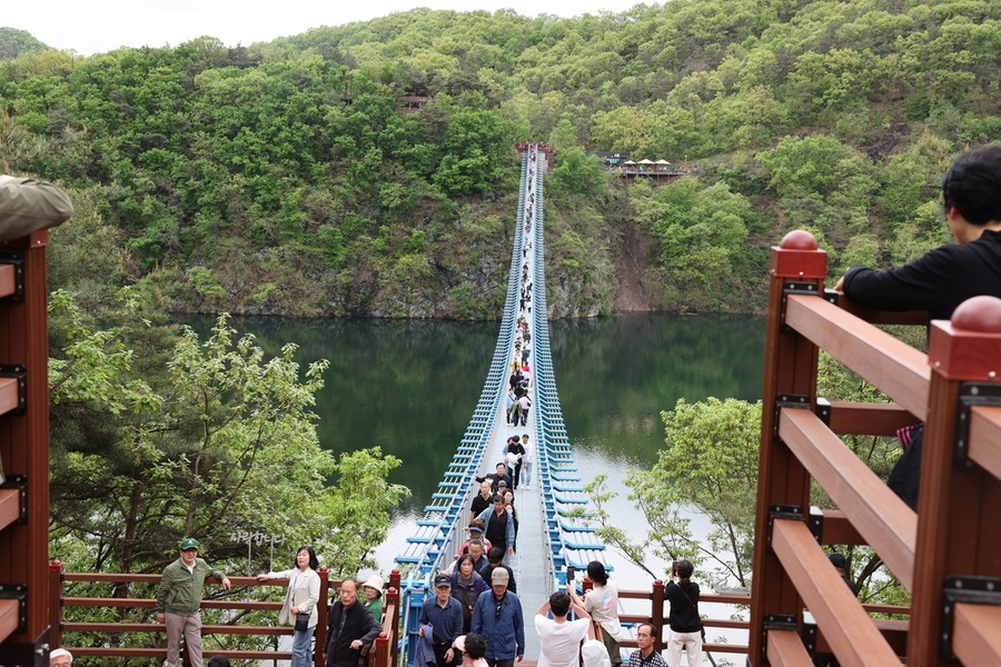 ▲ 관광객들이 ‘초평호 미르309 출렁다리’를 건너는 모습.ⓒ진천군