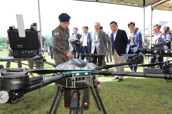 ▲ 23일 육군 25사단 예하의 육군 아미타이거(Army TIGER) 시범부대를 방문한 국방혁신위원회와 국방부 소속 국방혁신특별자문위원들이 25사단 만월봉대대장(중령 이진용)으로부터 아미타이거 여단의 전력화된 무기체계인 '소총사격드론'에 대해 설명을 듣고 있다. ⓒ국방부 제공