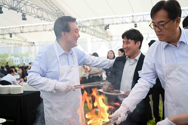 ▲ 윤석열 대통령이 24일 서울 용산 대통령실 잔디마당에서 열린 출입기자단 초청 만찬 간담회에서 직접 조리한 김치찌개, 계란말이, 스테이크를 출입기자들에게 배식하고 있다. (사진=대통령실 제공) 2024.05.24. ⓒ뉴시스