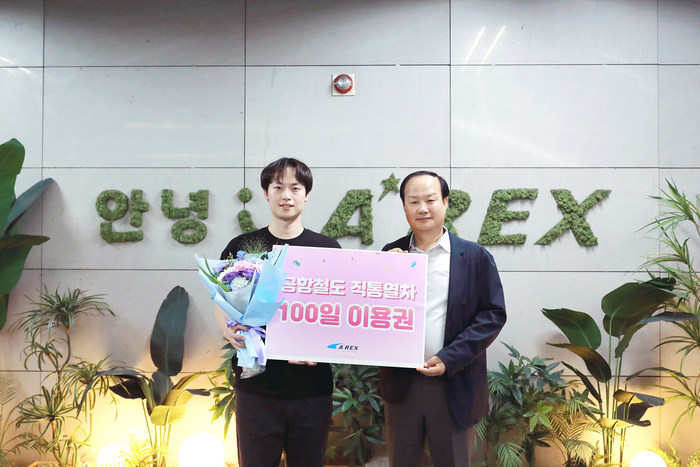 ▲ 김경순(우측) 공항철도 영업본부장이 승객 이종욱씨에게 직통열차 100일 이용권을 전달하고 있다.ⓒ공항철도 제공