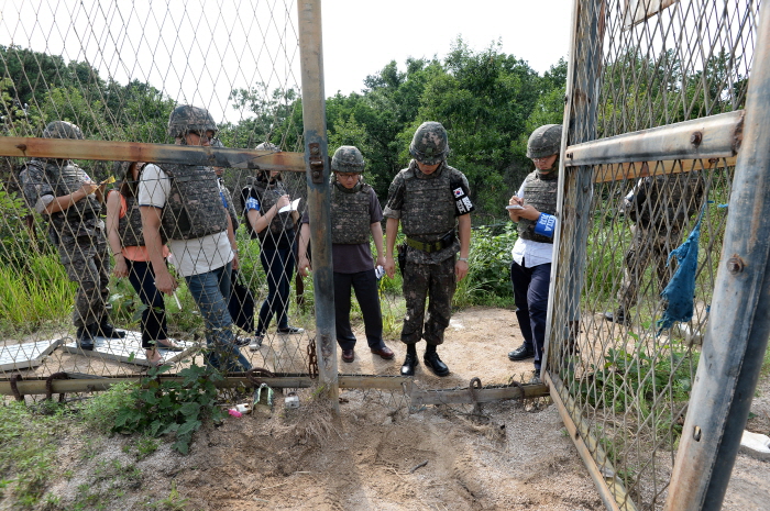 ▲ 지난 2015년 8월 4일 경기도 서부전선 비무장지대(DMZ)에서 육군 모부대 소속 장병들이 수색작전을 하던 중 '목함지뢰' 3발에 의해 김모·하모 하사 등 부사관 2명이 크게 다쳐 국군수도병원으로 이송돼 치료를 받았으며 생명에는 지장이 없는 것으로 밝혀졌다. 사진은 통문 북쪽 방향에서 사고지점을 바라보고 있는 취재진과 조사단장 모습. ⓒ국방부 제공