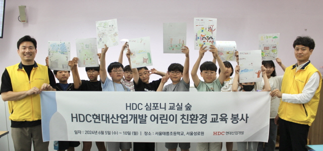 ▲ HDC현대산업개발 임직원이 태릉초교 어린이들과 기념촬영을 하고 있다. ⓒHDC현대산업개발