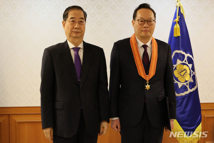 ▲ 한덕수 국무총리가 지난 2월 15일 오전 서울 종로구 정부서울청사에서 열린 규제개혁유공 포상 수여식에서 최현석 고용노동부 실장에게 홍조근정훈장을 수여한 후 기념촬영을 하고 있다. ⓒ뉴시스