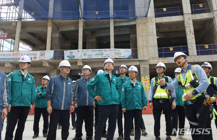 ▲ 박상우 국토교통부 장관과 이정식 고용노동부 장관이 12일 오전 장마철 대응 및 폭염 대비 상황 점검을 위해 서울 강동구 천호동 공동주택 재건축 정비사업 현장을 찾아 허유득 포스코이앤씨 안전팀장의 설명을 듣고 있다. ⓒ뉴시스