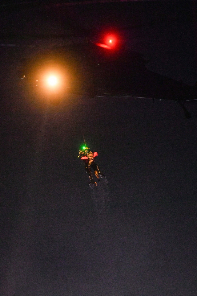 ▲ 항공구조사들이 호이스트와 레스큐시트를 활용해 조난 조종사를 HH-60 탐색구조헬기로 끌어올리고 있다. 공군 제6탐색구조비행전대는 7월 야간, 강릉 인근 동해상에서 항공구조사(SART) 15명과 HH-47, HH-60 등 탐색구조헬기 2대가 참가한 가운데, 전술임무 집중훈련을 연계한 '야간 수상수중 전투탐색구조훈련'을 실시했다. ⓒ공군 제공