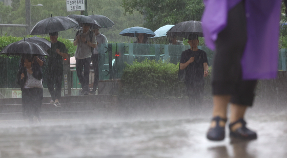 ▲ 서울 전역에 호우경보가 발효된 지난 17일 서울 중구 세종대로 사거리에서 우산을 쓴 시민들이 발걸음을 재촉하고 있다.ⓒ연합뉴스