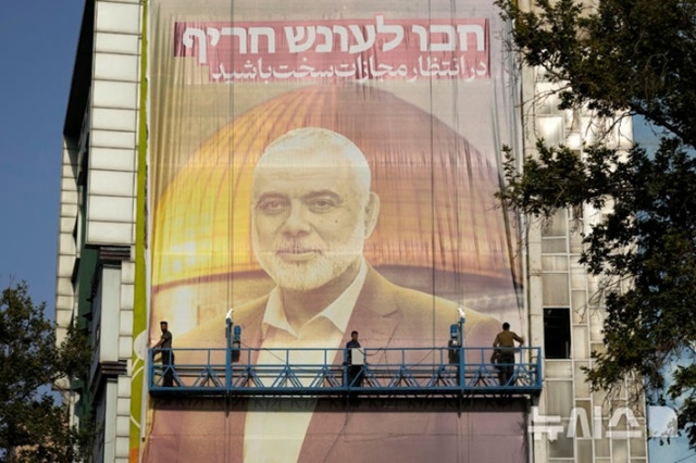 ▲ 이란에서 피살된 하마스 정치국 최고지도자 이스마일 하니예의 사진이 담긴 초대형 현수막이 이란 테헤란의 팔레스타인광장에 설치되고 있다. 240731 AP/뉴시스. ⓒ뉴시스