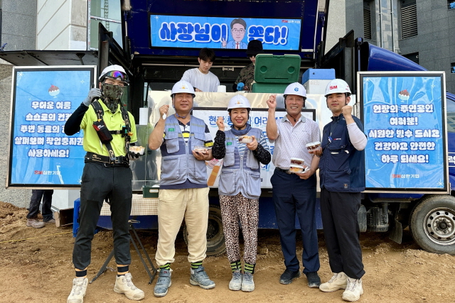 ▲ 경기 파주시 운정동 경남아너스빌 건축현장 근로자들이 팥빙수를 들고 기념촬영을 하고 있다. ⓒSM그룹 삼환기업