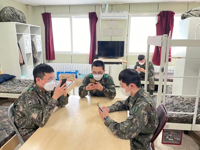 ▲ 사병들이 생활관에서 스마트폰으로 설문조사에 참여하고 있다. ⓒ육군 제공