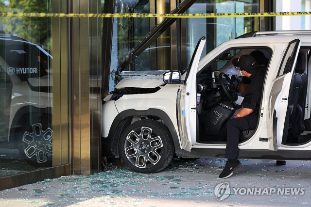 ▲ 서울 종로구 현대건설 사옥을 들이받은 소형 SUV 차량을 과학수사대가 현장조사하고 있다. ⓒ연합뉴스