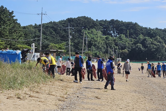 ▲ 경기도가 24일 제24회 '국제 연안정화의 날'을 기념해 궁평항 해안가 일대에서 실시한 해양환경보호 캠페인에 참석한 관계자들이 쓰레기를 수거하고 있다. ⓒ경기도 제공