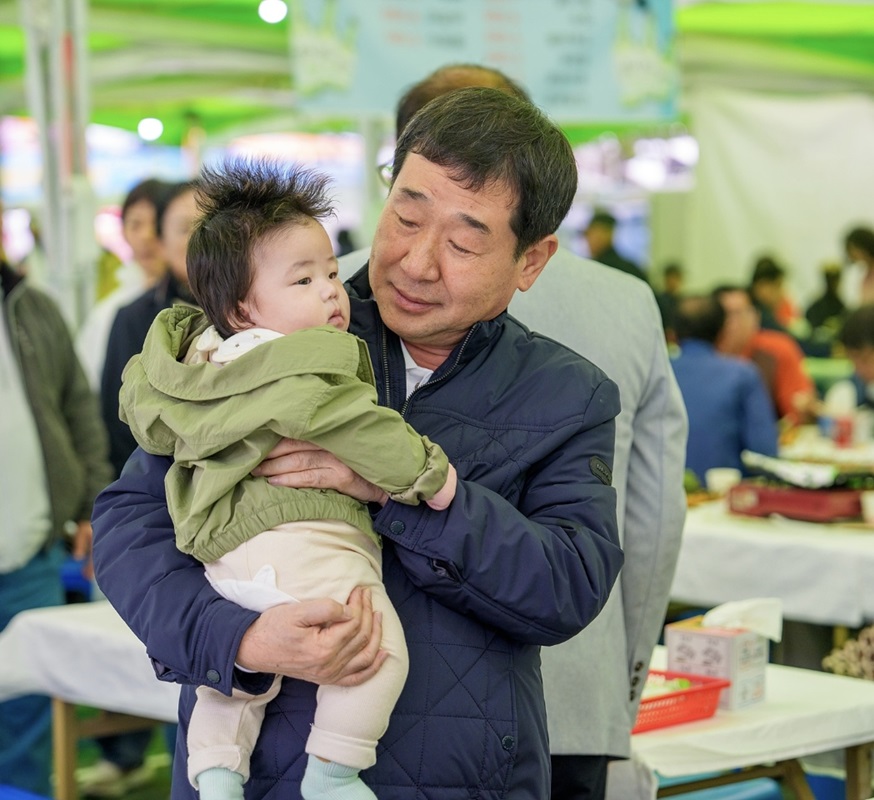 ▲ 이재영 증평군수가 인삼골 축제장에서 만난 아기를 안고 있다.ⓒ증평군