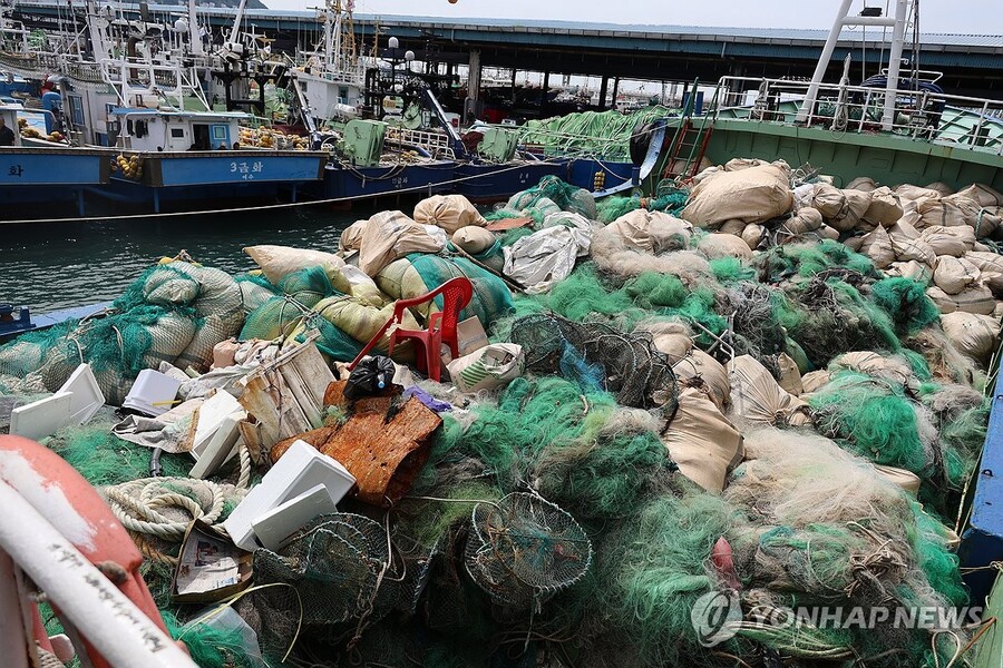 ▲ 바다의 날을 앞둔 지난달 27일 부산공동어시장에서 대형기선저인망수협이 제주 해역 인근에서 수거한 해양쓰레기 60t을 집게 차로 옮기고 있다. ⓒ연합뉴스