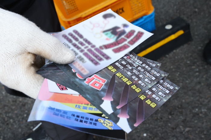 ▲ 24일 서울 용산구 대통령실 청사 인근에서 한 상인이 북한이 살포한 '쓰레기 풍선' 낙하물로 추정되는 '삐라(전단)'을 살펴보고 있다. ⓒ뉴시스