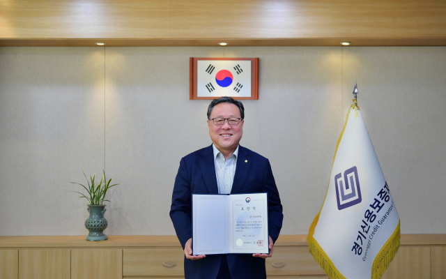 ▲ 시석중 경기신보 이사장이 ‘금융발전 유공 혁신금융부문 금융위원회 위원장 표창’을 들고 기념촬영을 하고 있다. ⓒ경기신보 제공
