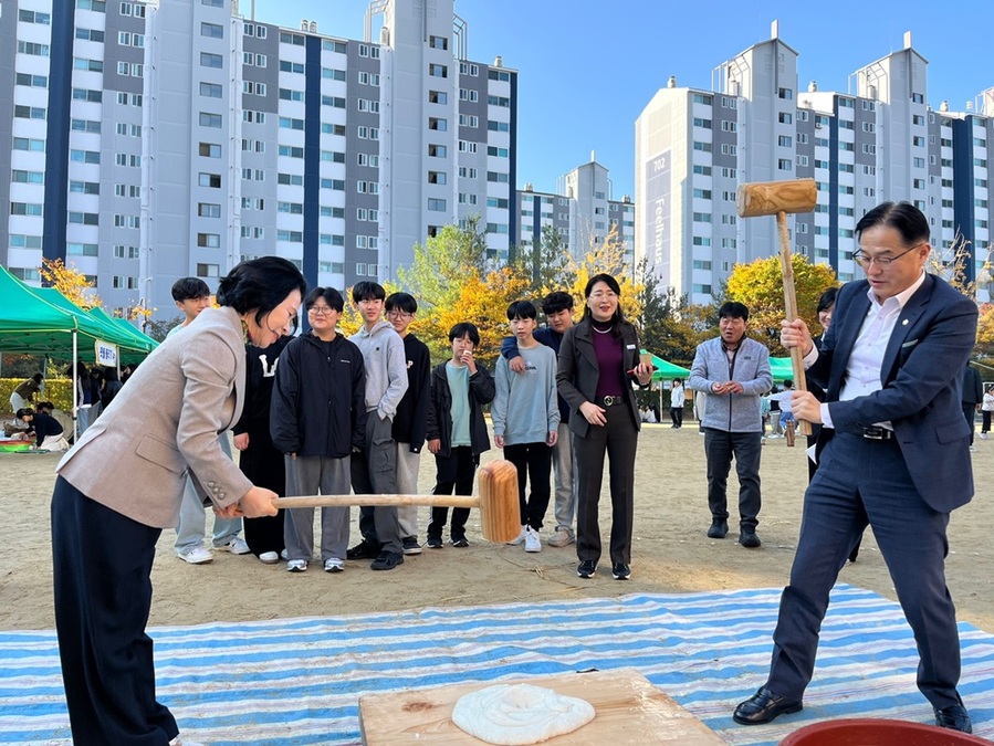 ▲ 김행금 천안시의장과 장혁 의원이 지난달 31일 서당초등학교에서 열린 추수축제에 참여해 떡메치기를 하고 있다.ⓒ천안시의회
